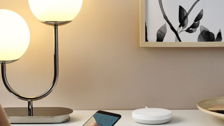 Eine Person h&auml;lt ein Smartphone in Richtung eines IKEA-Gateways.