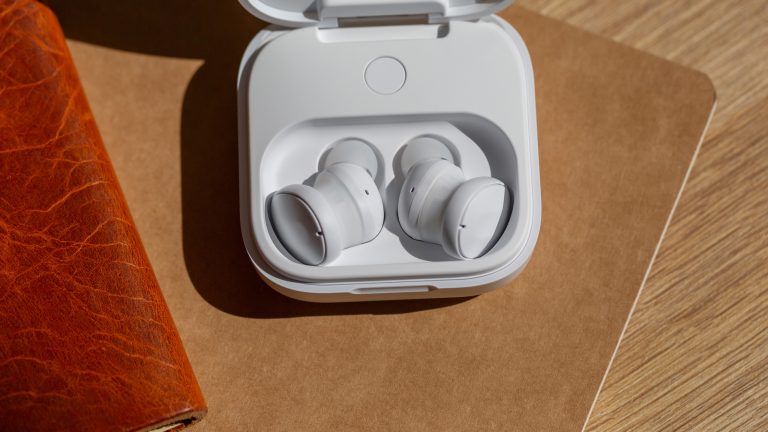 Die Fairbuds liegen im offenen Ladecase auf einem