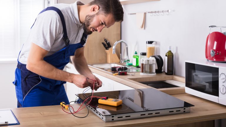 Eine Person überprüft den Strom an einer Herdplatte.