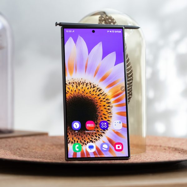 Ein eingeschaltetes Samsung Galaxy S24 Ultra steht in einer Dekoschale. Auf dem Ger&auml;t liegt der dazugeh&ouml;rige S Pen.