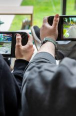 Zwei Personen sitzen nebeneinander und spielen auf einem Steam Deck OLED und Steam Deck LCD.