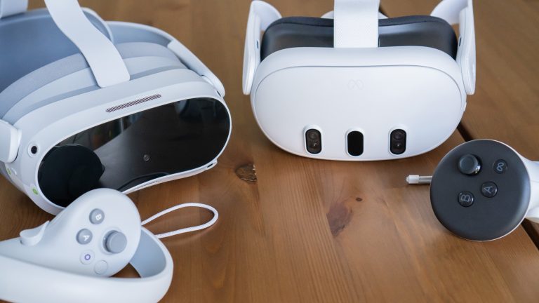 Eine Pico 4 liegt neben einer Meta Quest 3 auf einem Holztisch.