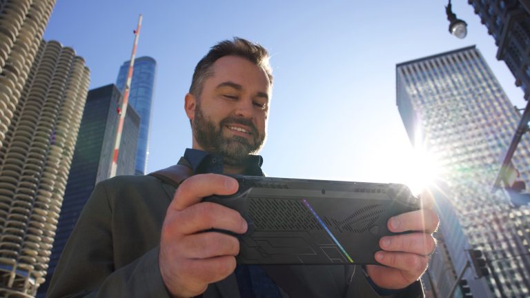 Eine Person hält ein ROG Ally X in der Hand, während sie in einer Stadt unterwegs ist.