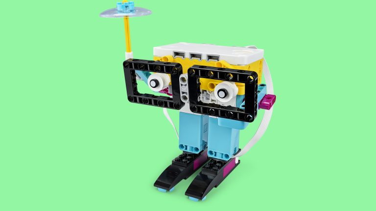 Produktbild von einem Spike-Set, das zu einem kleinen Roboter mit Brille und Regenschirm zusammengebaut wurde.