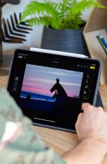 Bilder bearbeiten auf dem iPad Eine Person sitzt vor einem iPad Air M2 mit angeheftetem Apple Pencil Pro und bearbeitet ein Foto über die Fotos-App.