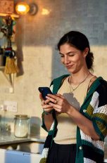 HyperOS 2.0, Neue Oberfläche für Xiaomi-Smartphones Eine Person hält ein Smartphone in der Hand, während sie in der Küche steht.
