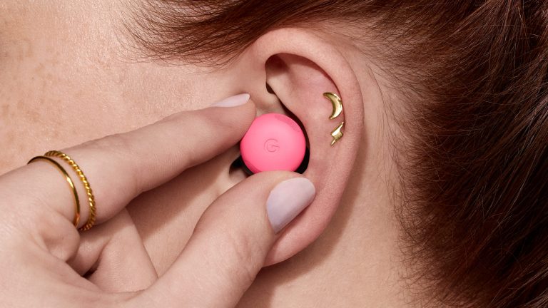 Das Ohr einer Person, in das sie mit einer Hand einen Bud Pro 2 einsetzt.