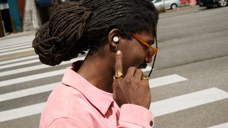 Eine Person an der Straße unterwegs. Sie trägt die Buds Pro 2 im Ohr und unterhält sich augenscheinlich damit.