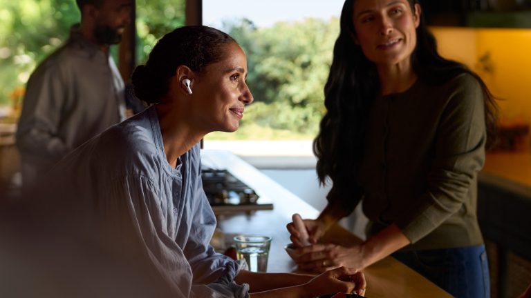 Eine Person unterh&auml;lt sich in der K&uuml;che mit einer anderen Person und tr&auml;gt AirPods Pro 2.