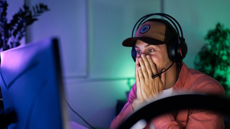 Eine Person mit Headset auf dem Kopf h&auml;lt sich die H&auml;nde vor das Gesicht.