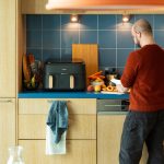 Eine Person schneidet in eine rK&uuml;che Fr&uuml;chte, neben ihr ist ein Airfryer von Philips zu sehen.)