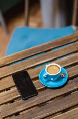 Ein Smartphone liegt auf einem Tisch in einem Caf&eacute;.