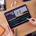 Eine Person sitzt vor einem iPad und h&auml;lt einen Apple Pencil in der Hand. Auf dem Display ist eine App f&uuml;r Videoschnitt zu sehen.