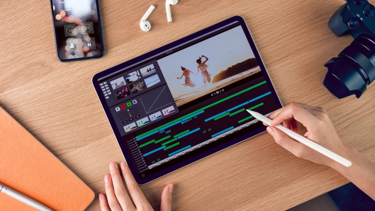 Eine Person sitzt vor einem iPad und h&auml;lt einen Apple Pencil in der Hand. Auf dem Display ist eine App f&uuml;r Videoschnitt zu sehen.
