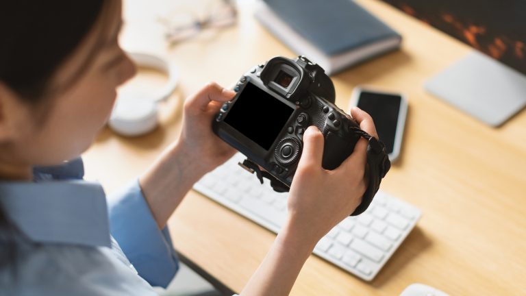 Eine Person h&auml;lt eine Digitalkamera in den H&auml;nden.