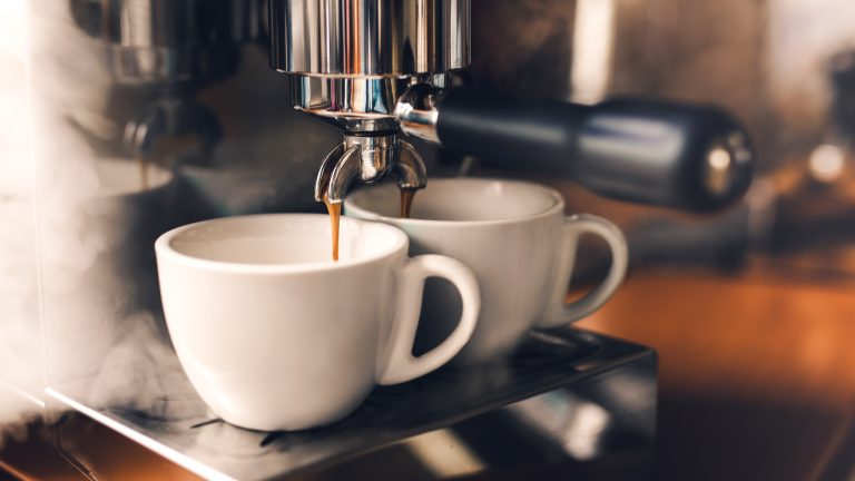 Eine Siebtr&auml;germaschine br&uuml;ht frischen Espresso in zwei darunter stehende Tassen.