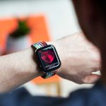 Eine Person tr&auml;gt eine Smartwatch am linken Handgelenk und checkt die Herzfrequenz auf dieser.