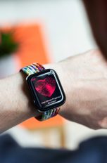 Eine Person tr&auml;gt eine Smartwatch am linken Handgelenk und checkt die Herzfrequenz auf dieser.