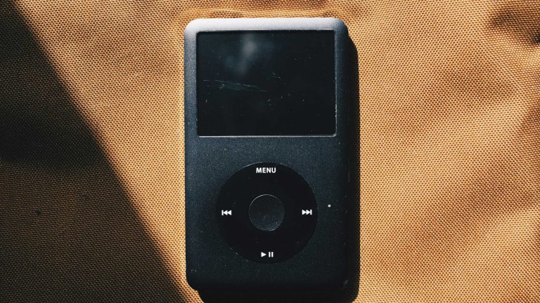 iPod, Warum er auch 2024 noch Sinn macht Ein schwarzer iPod liegt auf einem cognacfarbenen Untergrund.