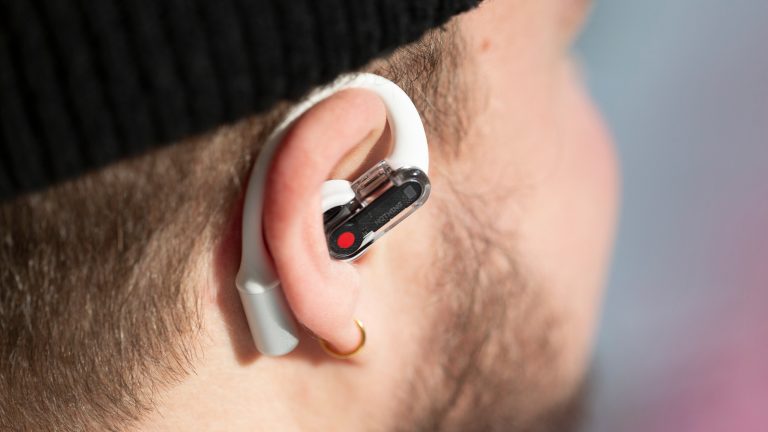 Nothing Ear (open), Stilvolles Design und innovative Technologie Eine Person trägt einen Nothing Ear (open) Bud im Ohr und der Ohrbügel schmiegt sich um das Ohr.
