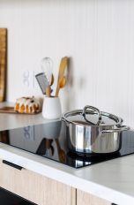 Induktionskochfelder, aktuelle Modelle für deine Küche Ein Topf steht auf einem Induktionskochfeld, das in eine Küchenzeile eingelassen ist.