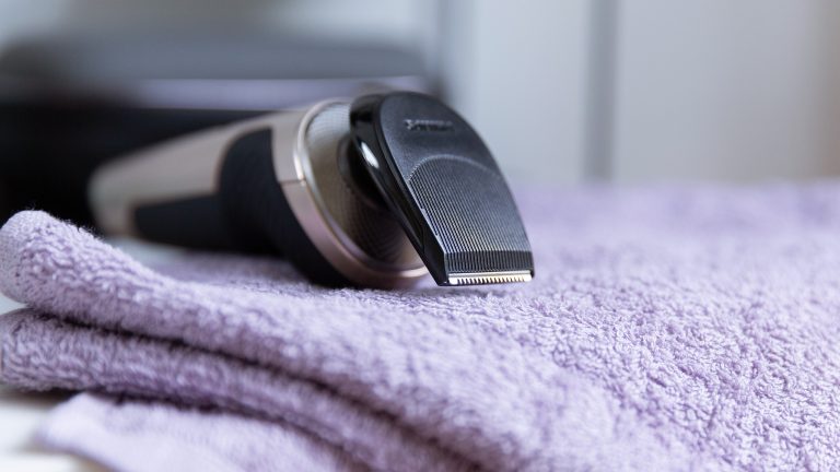 Der Philips S9000 Prestige mit dem Bartystyler-Aufsatz liegt auf einem Handtuch.