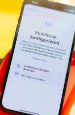 Auf einem iPhone ist die Funktion zu Mobilfunk-Konfiguration ge&ouml;ffnet. Es liegt auf einer bunten Unterlage.