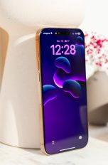 iPhone 16 Pro Max, Apples Flaggschiff ausprobiert Ein iPhone 16 Pro Max in Wüstensand steht an eine Vase gelehnt auf einem Regal.