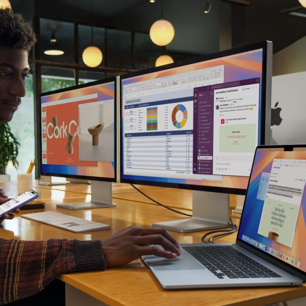 Eine Person sitzt vor zwei hochaufl&ouml;senden Displays, die an ein neues MacBook Air M4 angeschlossen sind.