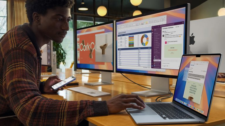 Eine Person sitzt vor zwei hochauflösenden Displays, die an ein neues MacBook Air M4 angeschlossen sind.