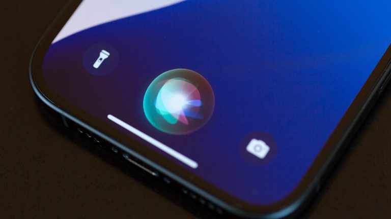 Nahaufnahme des unteren Drittels eines iPhone-Displays auf dem Siri aktiv ist.