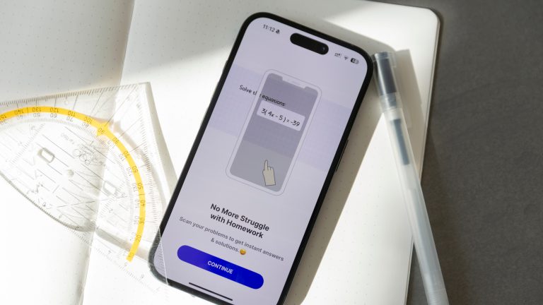 Ein iPhone liegt auf einem geöffneten Notizbuch, daneben ein Stift und ein Geodreieck. Auf dem Display ist die Socratic-App geöffnet.