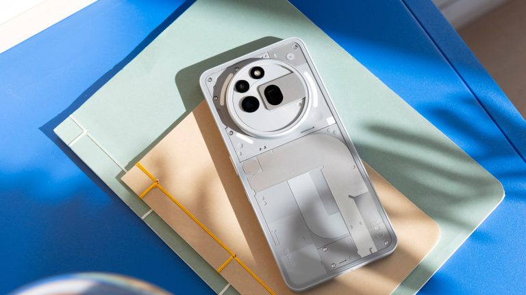 Ein Nothing Phone 3(a) Pro in Grau liegt mit der Rückseite nach oben auf einem Hefter.