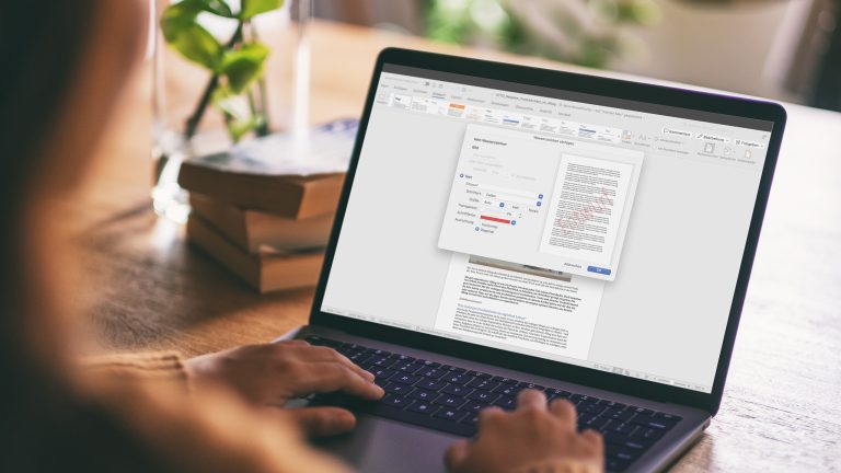 Eine Person sitzt vor einem Notebook. Auf dem Display ist ein ge&ouml;ffnetes Word-Dokument zu sehen; dar&uuml;ber liegt das Fenster zur Einrichtung eines Wasserzeichens.