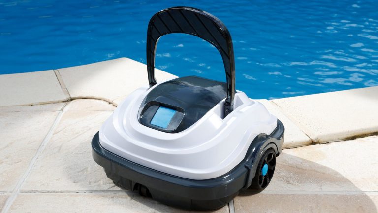 Ein Poolroboter steht auf hellen Bodenfliesen am Rand eines Pools.