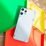 Ein CMF Phone 2 Pro liegt mit der R&uuml;ckseite nach oben auf bunten Schalen.