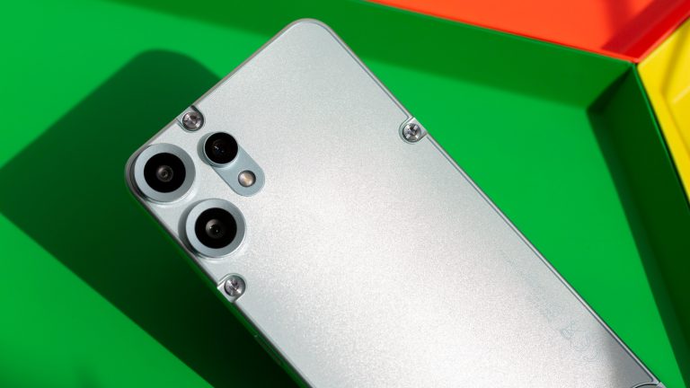 Ein CMF Phone 2 A liegt mit der R&uuml;ckseite nach oben auf einer gr&uuml;nen Schale.