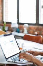 Facebook-Videos downloaden, So klappt’s Eine Person sitzt an einem Laptop und hat die Facebook-Anmeldeseite geöffnet.