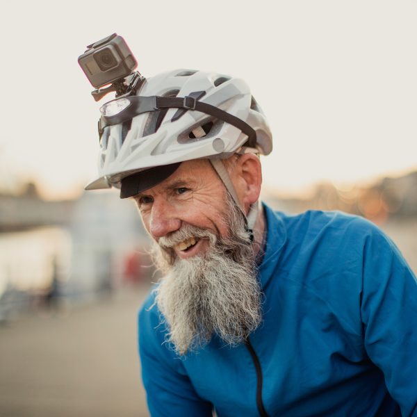 Eine Person trägt einen blauen Windbreaker und einen Fahrradhelm auf dem eine Actionkamera befestigt ist.