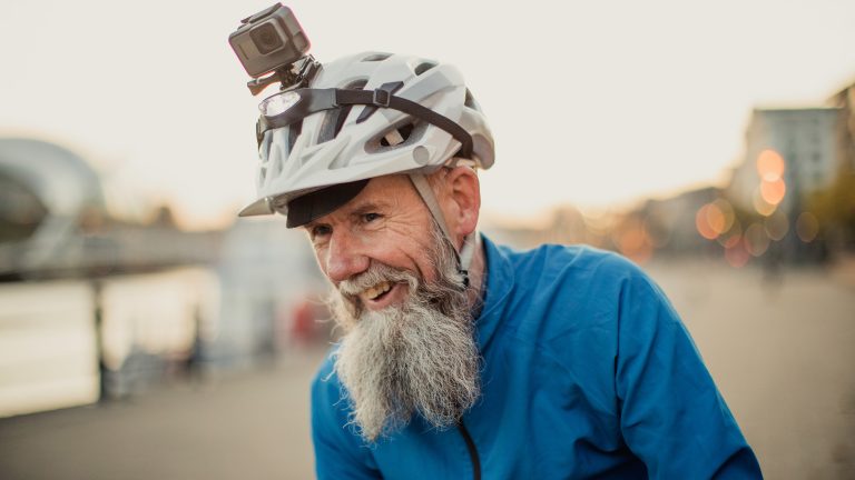 Eine Person trägt einen blauen Windbreaker und einen Fahrradhelm auf dem eine Actionkamera befestigt ist.
