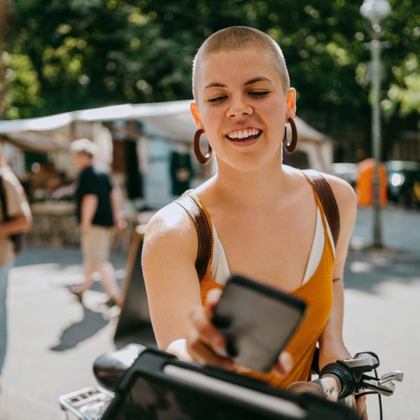 Eine Person steht mit ihrem Handy vor einem Stand und bezahlt per Google Pay.