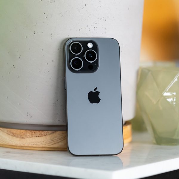 Ein iPhone 15 Pro lehnt an einem Blumentopf.