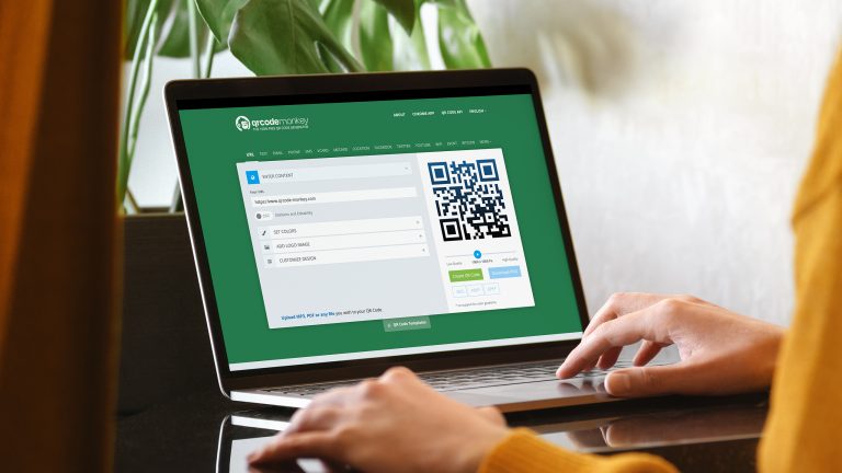 Eine Person sitzt an einem Laptop und generiert online einen eigenen QR-Code.