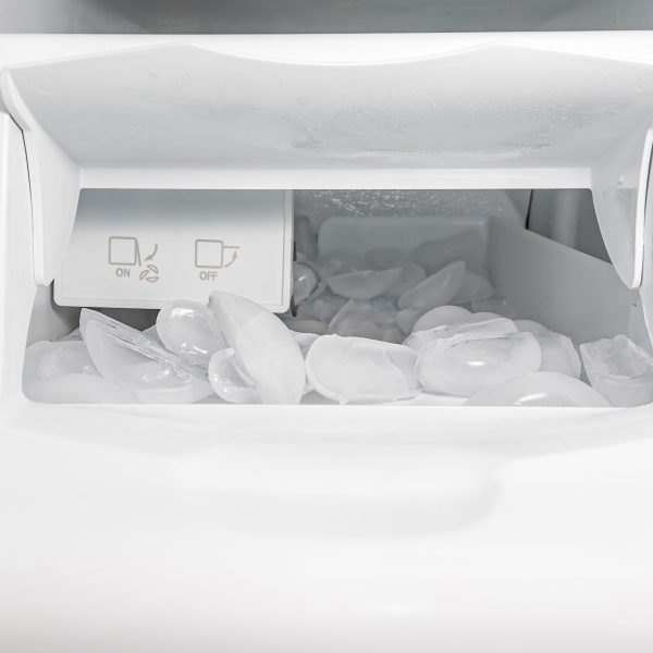 Blick in das Innere einer Eisw&uuml;rfelmaschine, in der bereits zahlreiche Eisw&uuml;rfel liegen.