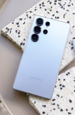 Ein Samsung Galaxy S25 Ultra und der zugehörige S-Pen liegen auf kleinen Marmorfliesenstücken auf einem Tisch. Im Anschnitt unten links ist eine Pflanze zu sehen.