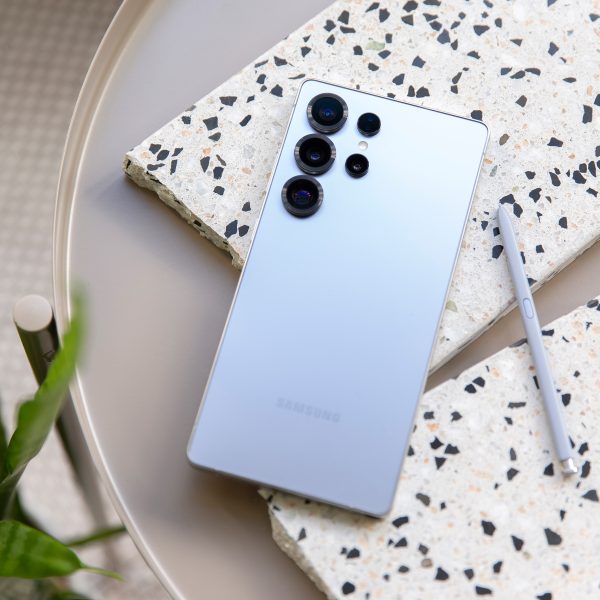 Ein Samsung Galaxy S25 Ultra und der zugeh&ouml;rige S-Pen liegen auf kleinen Marmorfliesenst&uuml;cken auf einem Tisch. Im Anschnitt unten links ist eine Pflanze zu sehen.