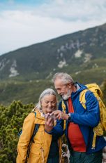 Zwei Personen in Wanderkleidung stehen in einer abgelegenen Berglandschaft.