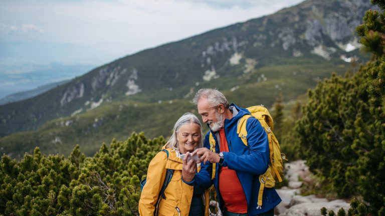 Zwei Personen in Wanderkleidung stehen in einer abgelegenen Berglandschaft.