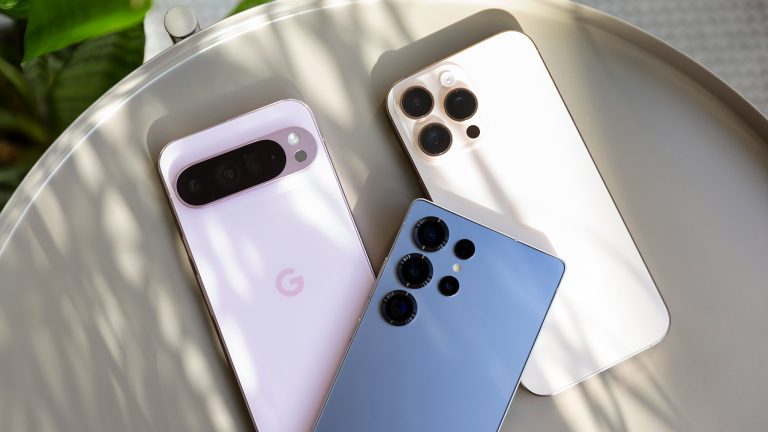 Ein Samsung Galaxy S25 Ultra, ein Google Pixel 9 Pro XL und ein Apple iPhone 16 Pro Max liegen zusammen auf einem kleinen Tisch.