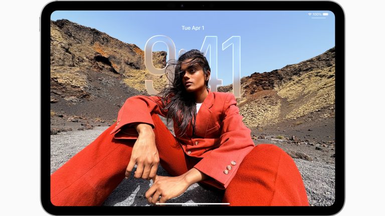 macOS 26 & iPadOS 26, Wer braucht jetzt noch einen Mac? Ein iPad mit einer freigestellten Person vor bergigem Hintergrund und durchscheinender Uhrzeit.